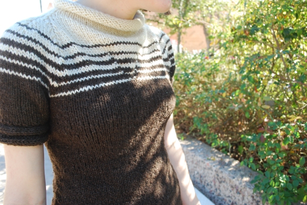 Girl wearing a knitted dress with a brown and white striped yoke