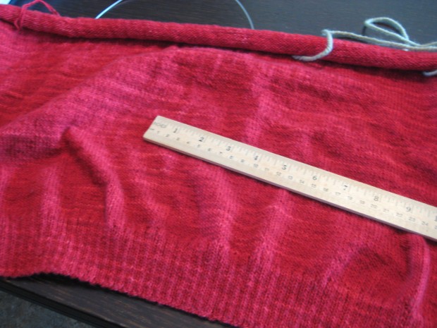 Wooden ruler atop a piece of red hand-knitted fabric
