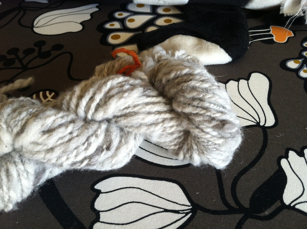 Gray and cream heathered yarn on a patterned background.