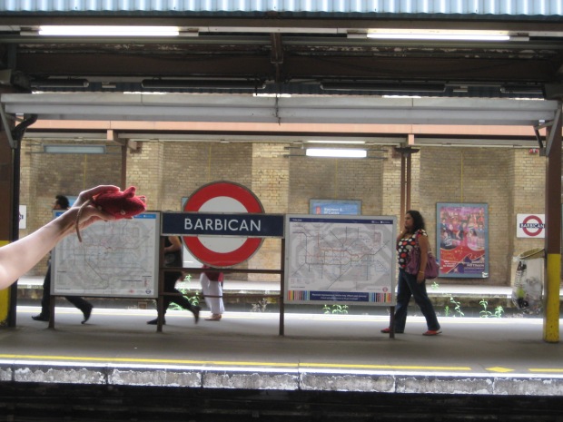 Red knitted mouse by the Barbican Tube sign