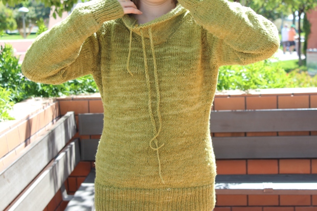 Girl putting on a green sweater