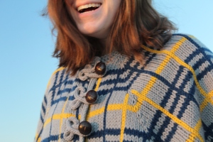 Woman wearing a knitted plaid cape
