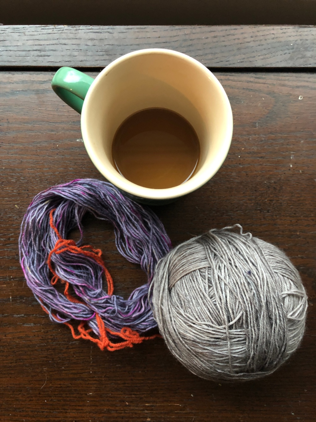 Purple and gray yarns from Less Traveled Yarns and a coffee mug